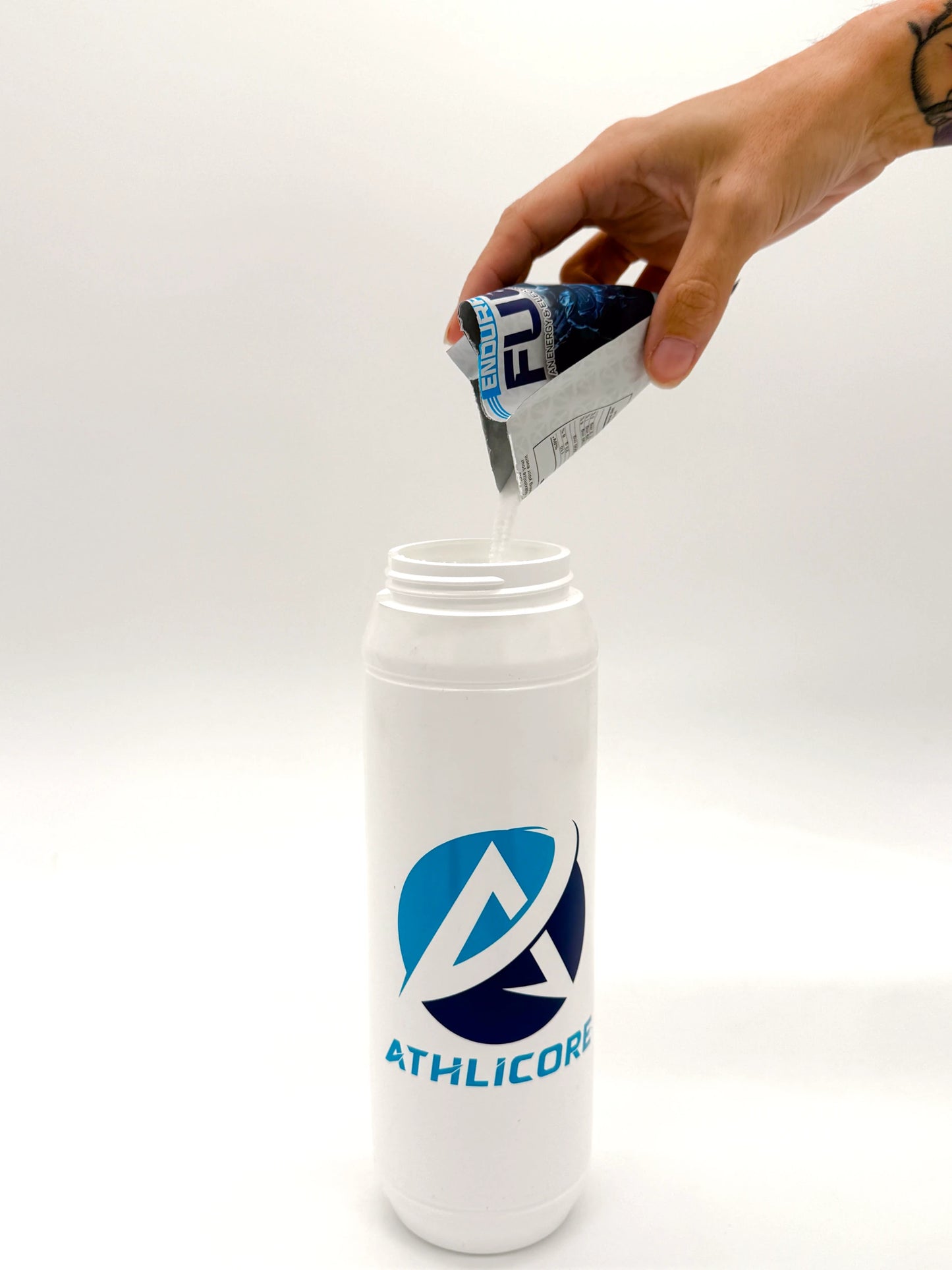 30g pouch of Endurance Fuel being poured into Athlicore water bottle.